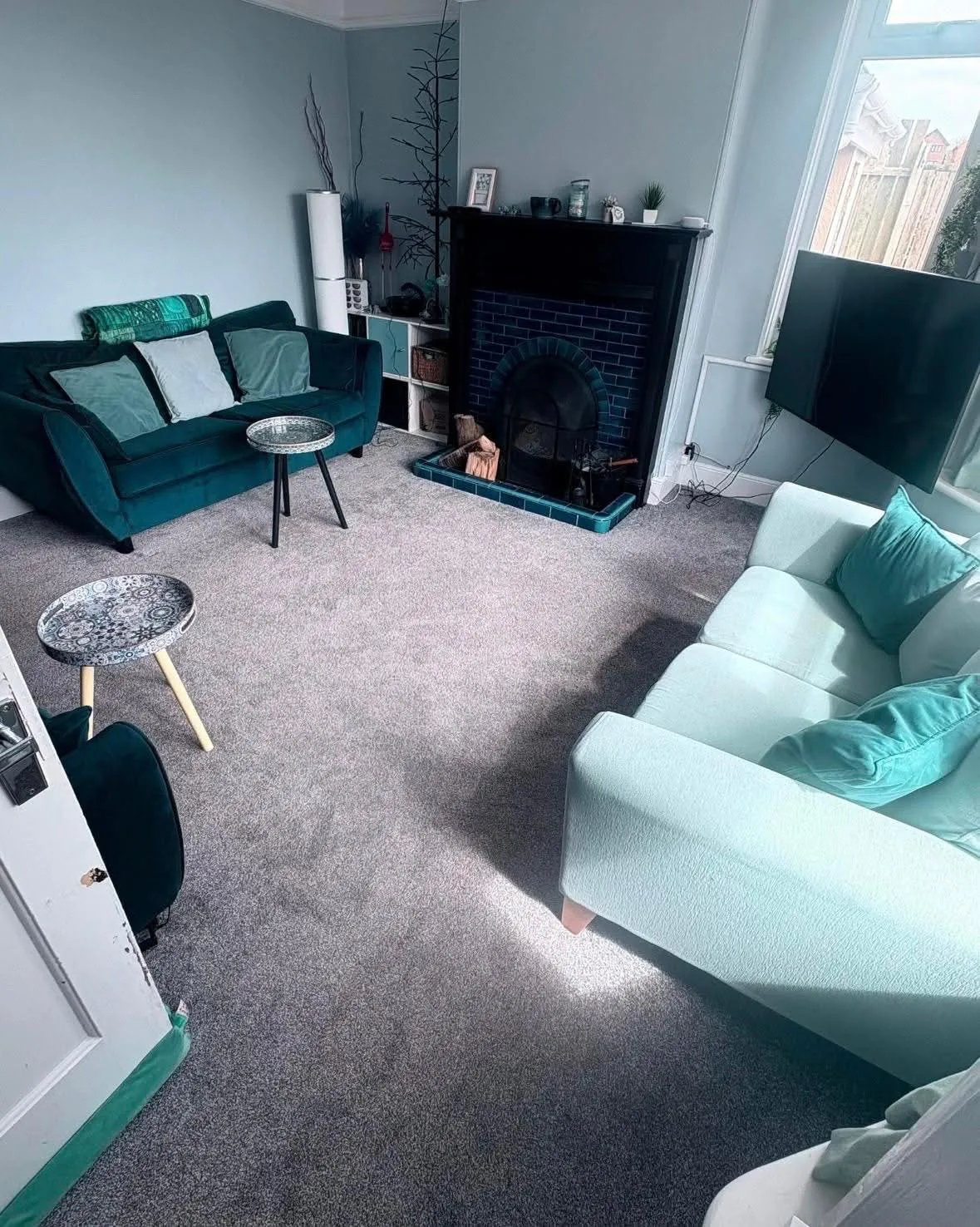 Tidy, freshly cleaned living room with teal sofas